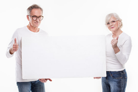 Senior beautiful couple with empty white board.