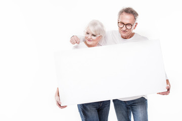 Senior beautiful couple with empty white board.