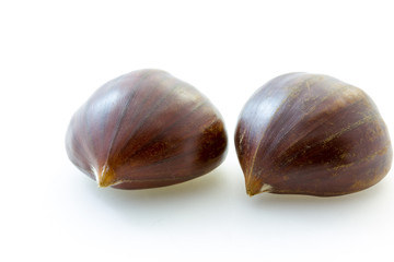 Two tasty uncooked chestnuts with white background