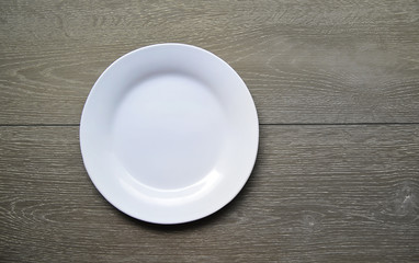 Empty white plate on a wooden background 