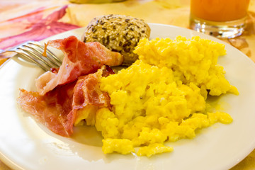 Scrambled eggs with bacon and bread with seeds