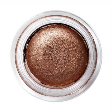 Copper color eye shadow in round container on background