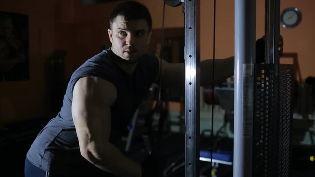 extension arms in the simulator, training triceps. bodybuilder training . gym.