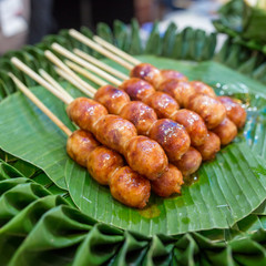 Traditional Thai style grilled Sausages on the banana leaf. Isaan pork meat sausage.