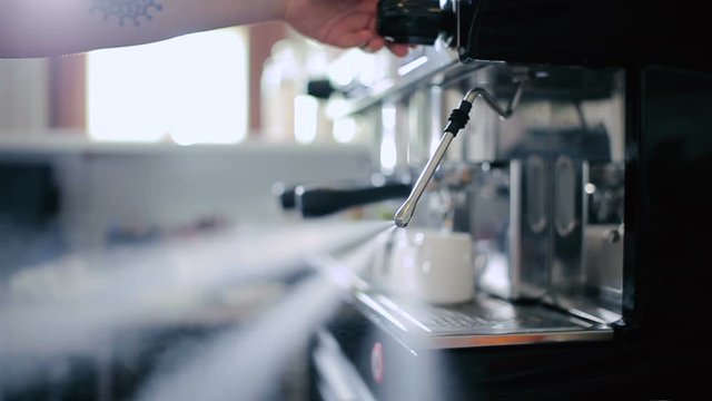 Bartender adds cream to freshly prepared coffee.