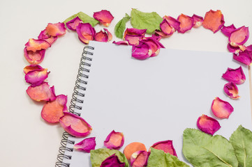 Black notepad. Love concept Realistic template notebook. Blank cover design. with dried rose petals and leaf. on cardboard background.