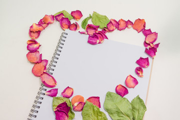 Black notepad. Love concept Realistic template notebook. Blank cover design. with dried rose petals and leaf. on cardboard background.
