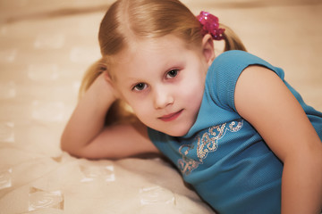 Fototapeta premium Little blonde girl on the bed