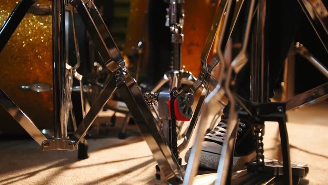 Drummer's foot in sneakers moving drum bass pedal, slider