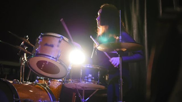 Emotional girl percussion drummer performing with drums, slider