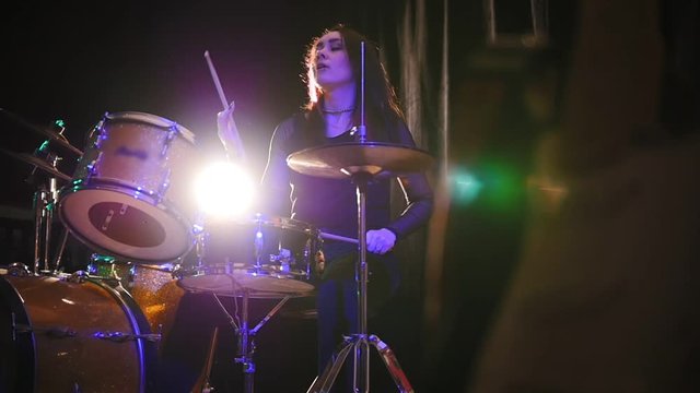 Teen rock music - emotional girl percussion drummer performing with drums, slow-motion
