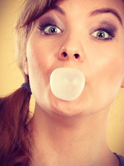 Blonde girl chewing gum making balloon.