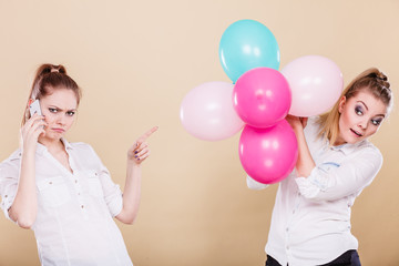 Fototapeta premium Two girls with mobile phone and balloons