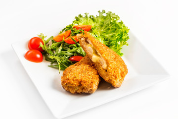 Fried golden chicken with cheese and vegetables on plate isolated at white background.