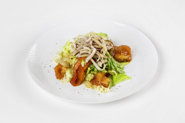 Plate of fresh calamari salad with vegetables isolated at white background.