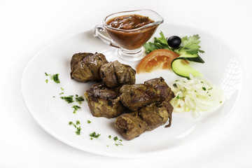 Plate of grilled shashlik with tomato sauce isolated at white background.