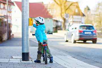 Little preschool kid boy riding with his first green bike