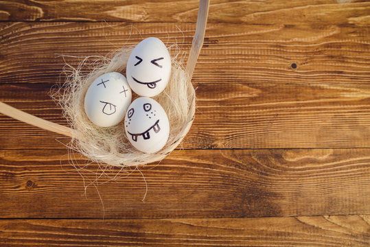 Eggs with painted smiling faces in a basket