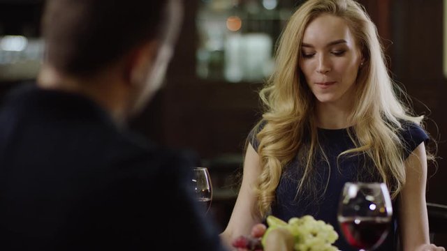 smiling cute lady giving a present to valentines day to a man