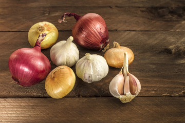 Garlic and onion bulbs on dark wooden background