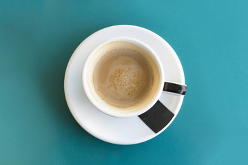 Cup of coffee on turquoise with copyspace