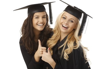 Beautiful female graduates showing ok sign