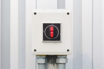 Industrial switch control button for electrical control outside factory building.
