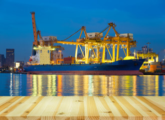 Obraz premium Gantry crane loading and unloading cargo container from cargo ship at port to show global international logistics and transportation by cargo ship and cargo container, Logistic import export concept.