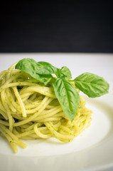 Italian pasta spaghetti with homemade pesto sauce and basil leaf