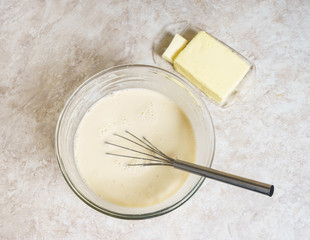 The process of cooking pancakes for breakfast. Oil and dough for crepes.