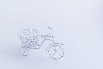 Fototapeta na wymiar Small decorative white bicycle on a white background. Background mode.