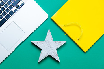 beautiful star shaped toy, cool shopping bag and modern silver laptop on the wonderful blue...
