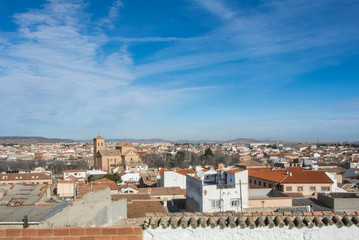 Obraz premium A panoramic view to spanish town Consuegra (Castilla-La Mancha) over the orange tile roofs on sunny day.