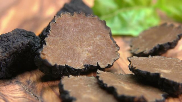 a circular motion around the black truffle chopped on slices