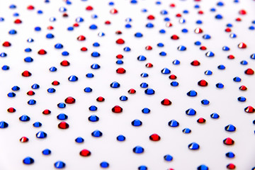 Rhinestones blue and red on a white background acrylic.
