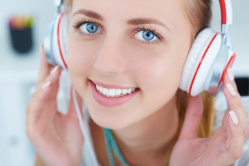 Naklejka premium Close-up portrait of young beautiful girl listening to music with pleasure.