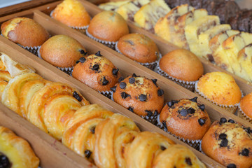 Assorted pastries in wooden box (chocolate chip muffin, butter cake, croissant)