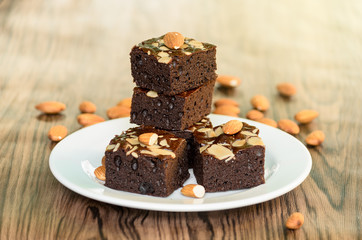 Almond Dark Brownies in white plate on wood table background.