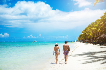 Obraz premium Back view of couple walking down seaside enjoying good time.