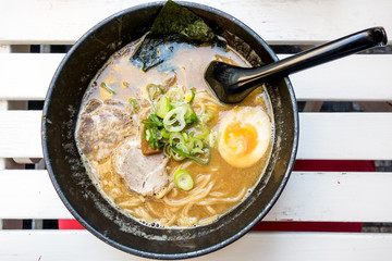 Tasty Japanese ramen soup bowl with pork, egg, and vegetables