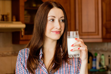 Girl with a glass of milk in the kitchen