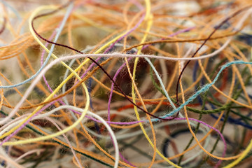 Multi-colored tangled colorful needlecraft silk thread rope. Macro shot. Abstract colors background
