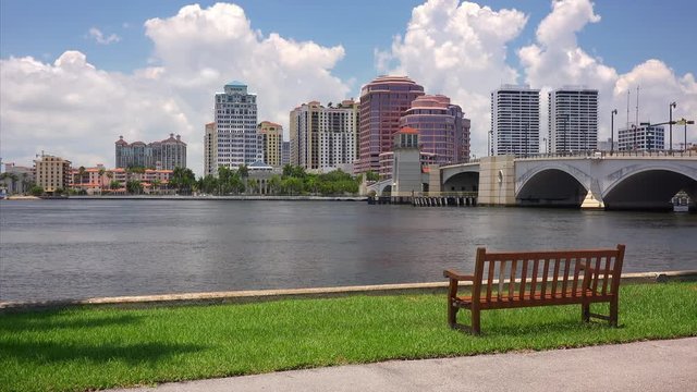 An empty wooden bench sit along the marina in West Palm Beach, Florida