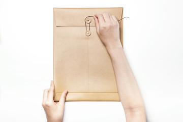 Woman hand hold a letter with leather envelope isolated white