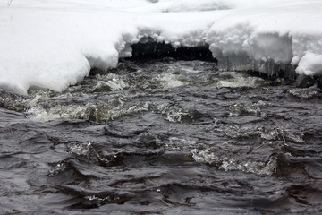 Beginning of winter. Snowing over frozen river
