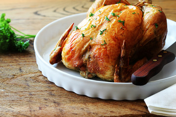 Roasted whole chicken on wooden table