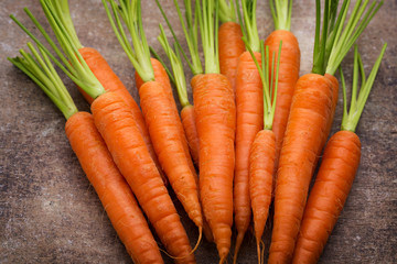 Fresh and sweet carrot on a grey wooden table.
