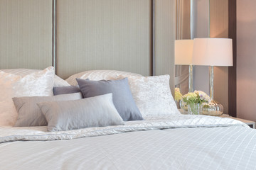 Classic bedroom interior with pillows and reading lamp on bedside table