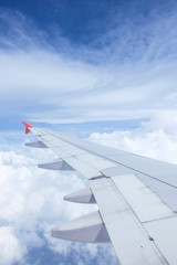 Obraz premium Airplane wing on beautiful dramatic sky with cloud