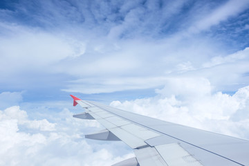 Fototapeta na wymiar Airplane wing on beautiful dramatic sky with cloud